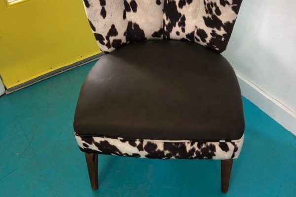 A cow print upholstered chair.