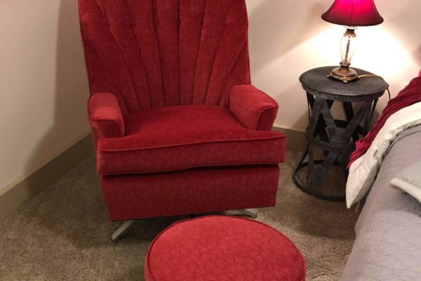 Matching red armchair and foot stool set.